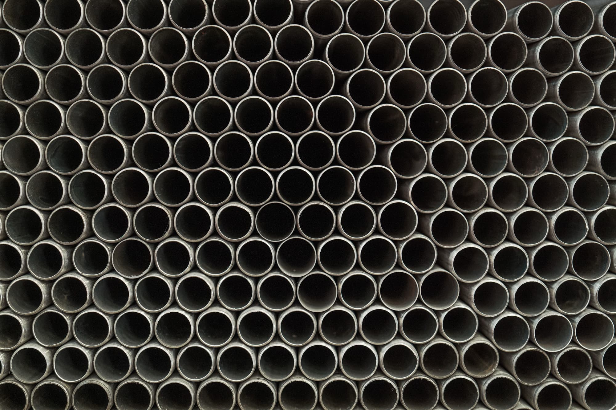 Steel tubes stacked end-on in a tight honeycomb, every one identical